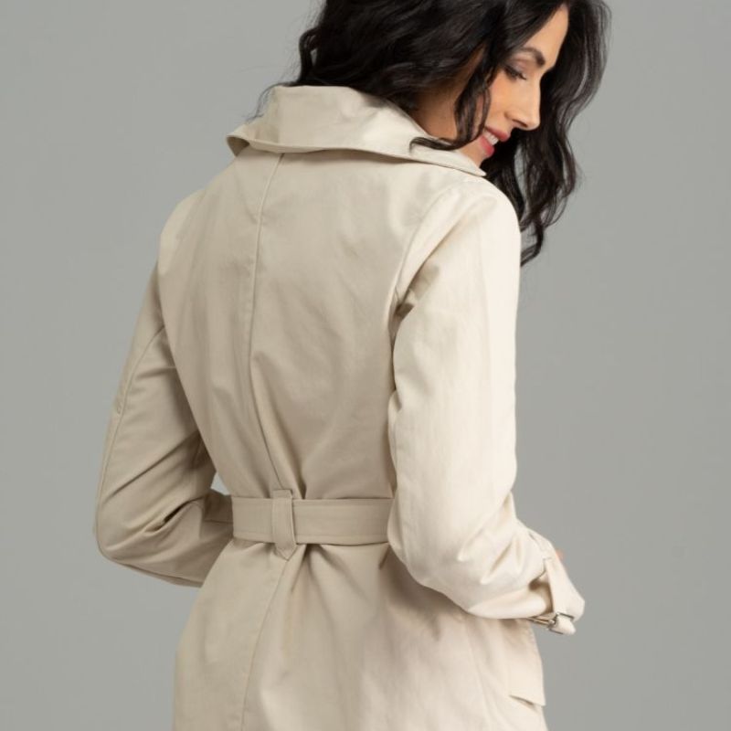 Donna di spalle che indossa uno spolverino corto con cintura, color sabbia